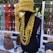 A display of handmade knitted items including a mannequin wearing a yellow-green knitted hat and several layered necklaces. Various colorful knitted scarves, hats, and accessories are arranged on a table and hanging in the background.