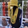 A display of handmade knitted items including a mannequin wearing a yellow-green knitted hat and several layered necklaces. Various colorful knitted scarves, hats, and accessories are arranged on a table and hanging in the background.