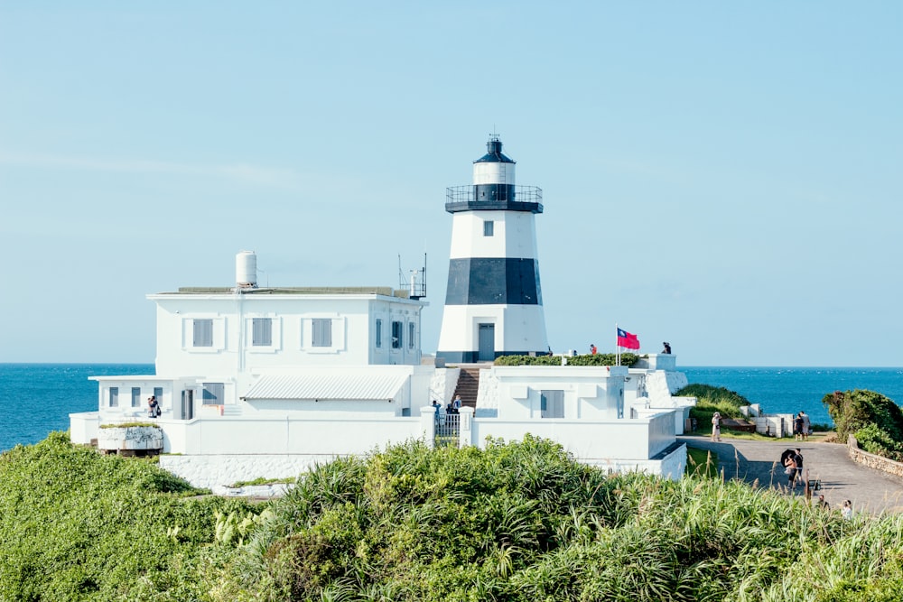 a lighthouse on top of a hill next to the ocean