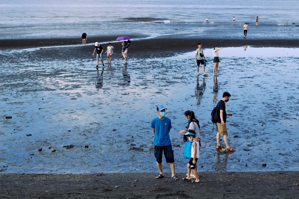 a group of people standing on top of a beach