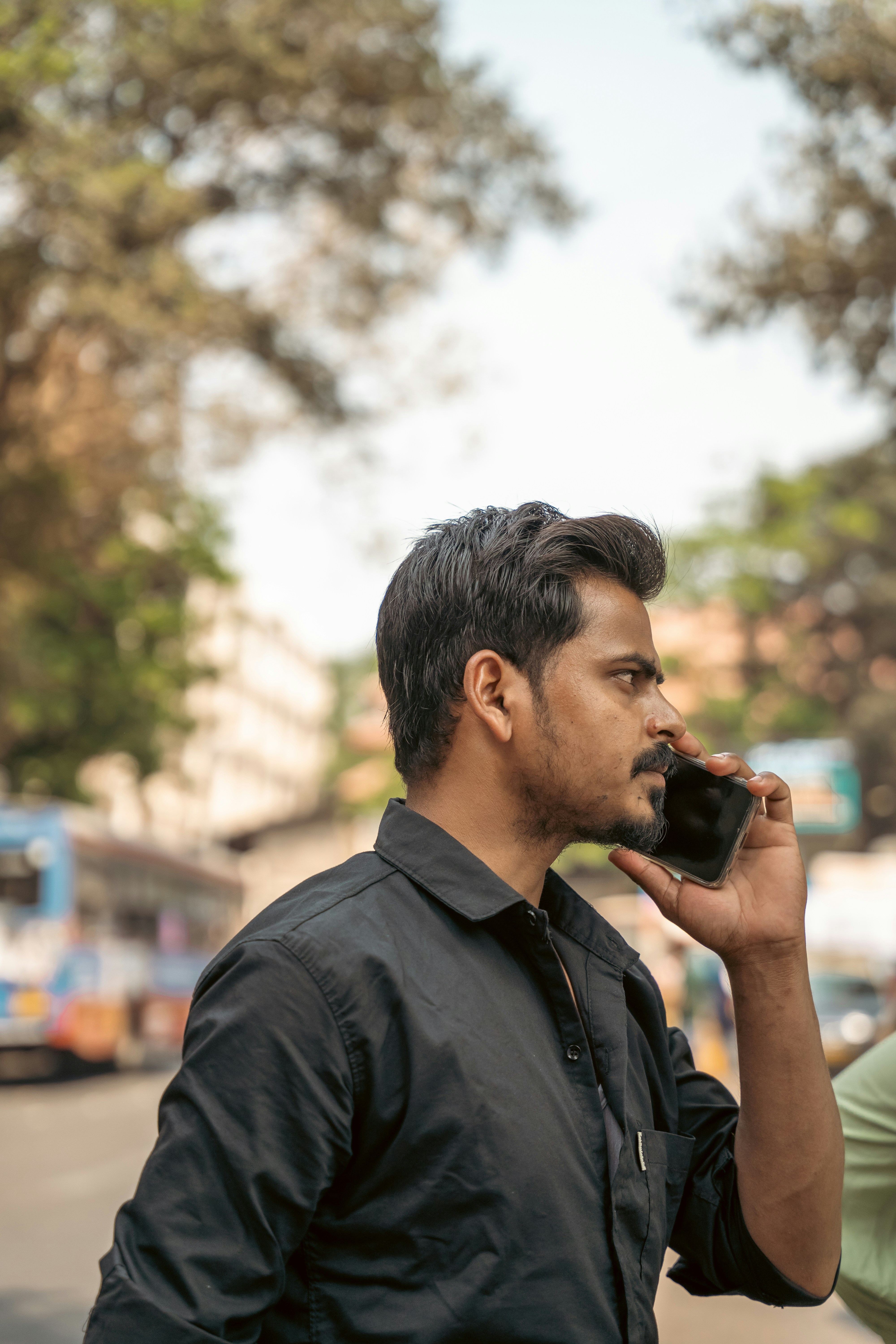 a man talking on a cell phone while standing on a street