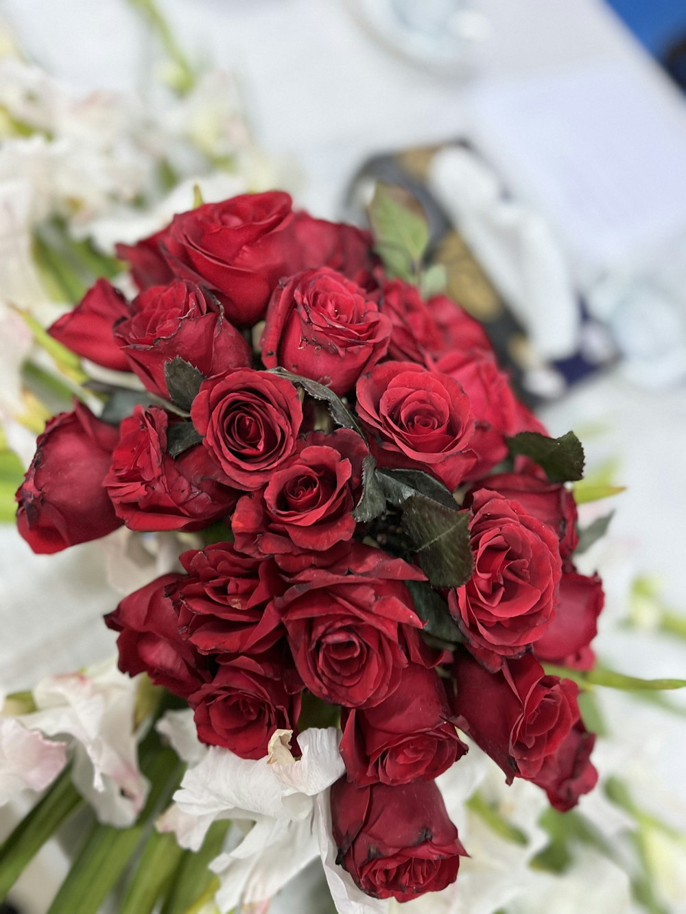 a bouquet of red roses sitting on top of a table