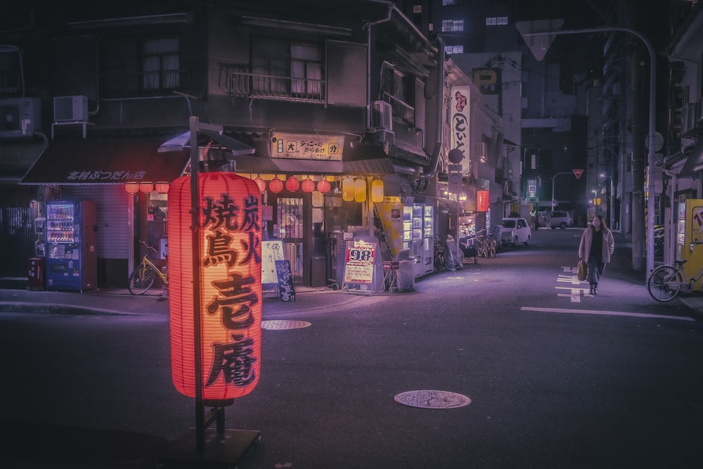 a city street at night with asian writing on it