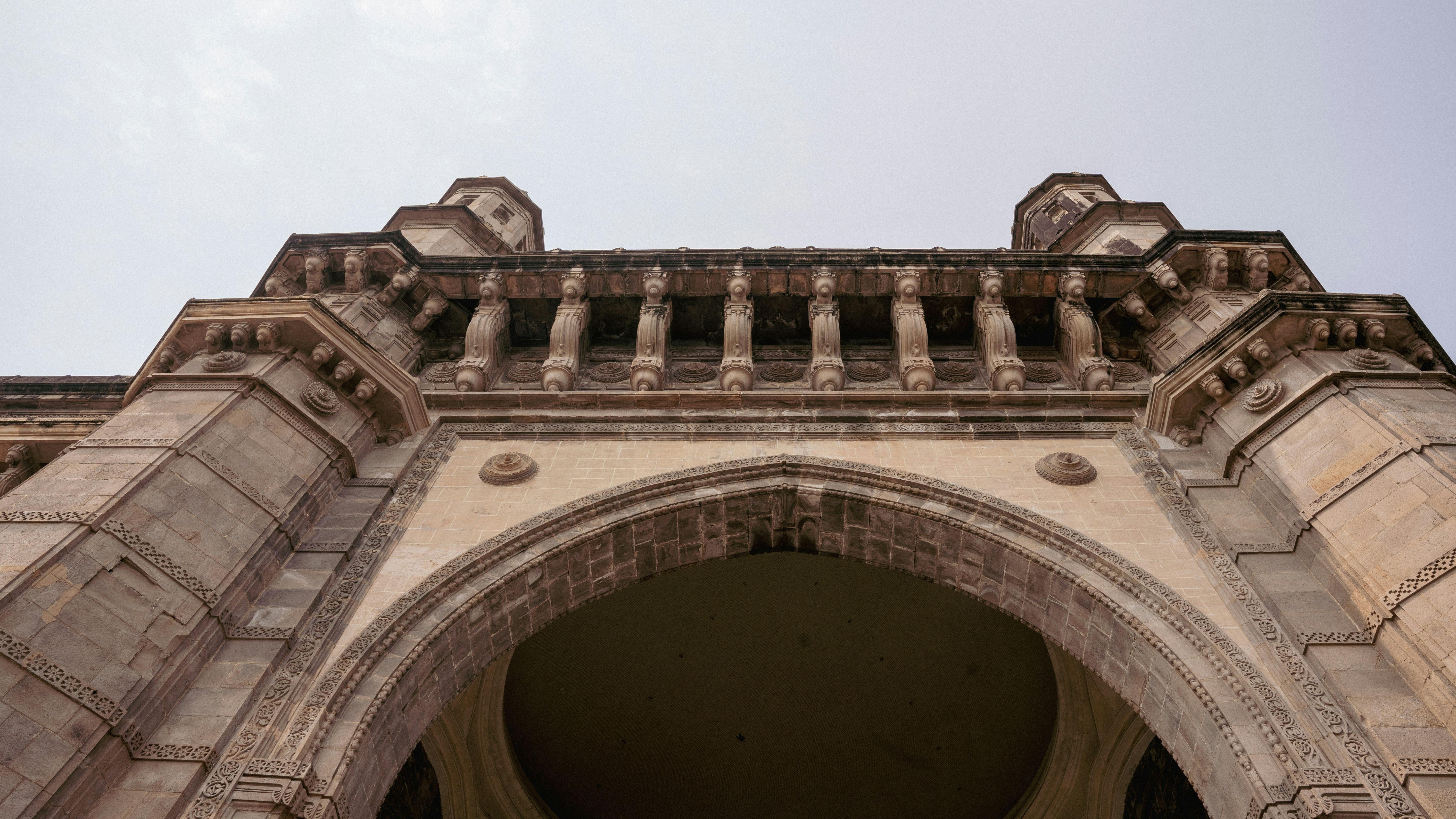 a stone arch with a clock on the top of it