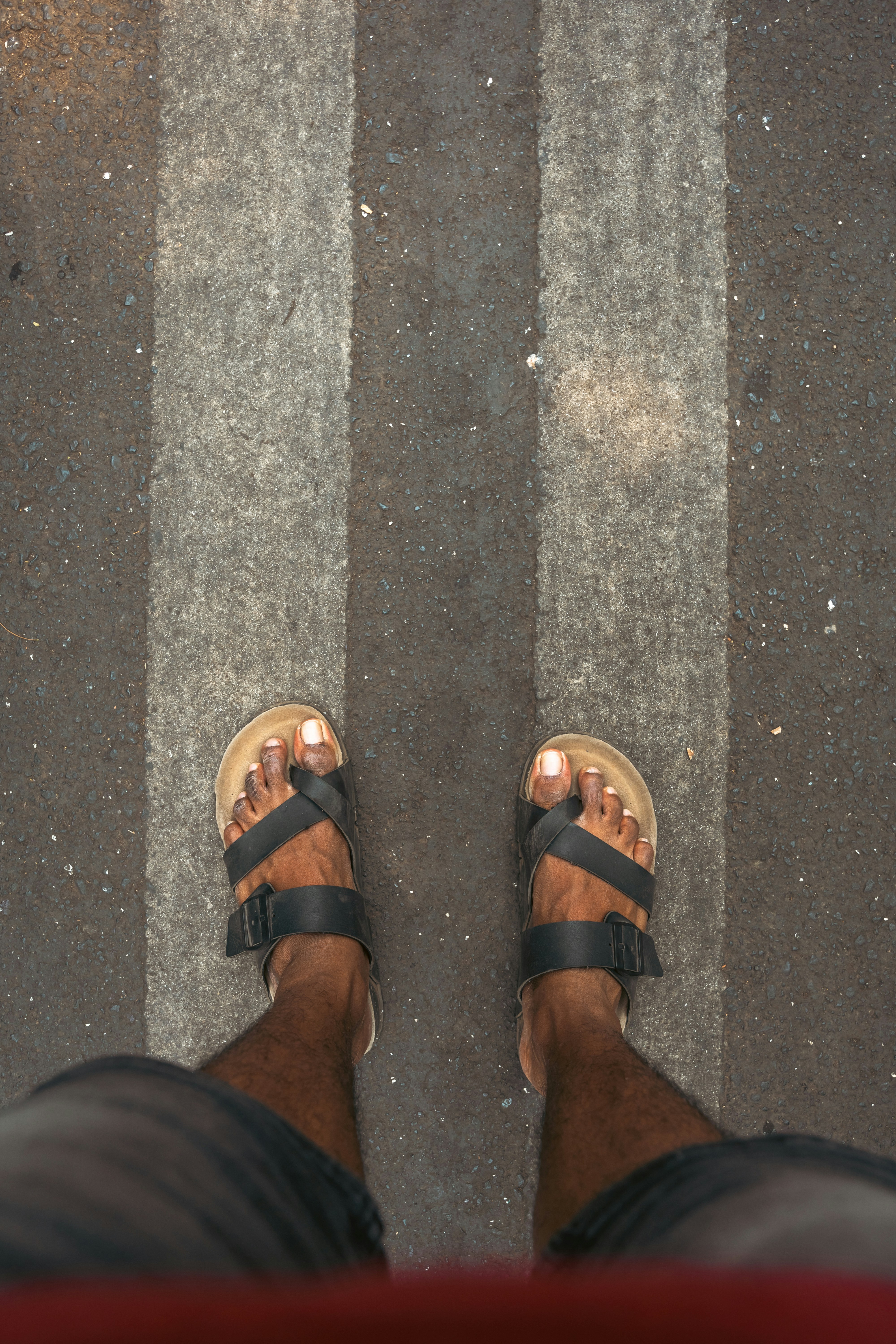 une personne portant des sandales debout dans une rue