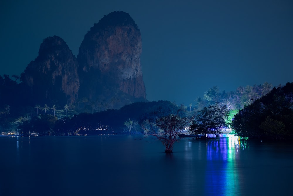 a lake at night with a mountain in the background