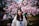 Smiling woman standing in front of cherry blossoms in Japan