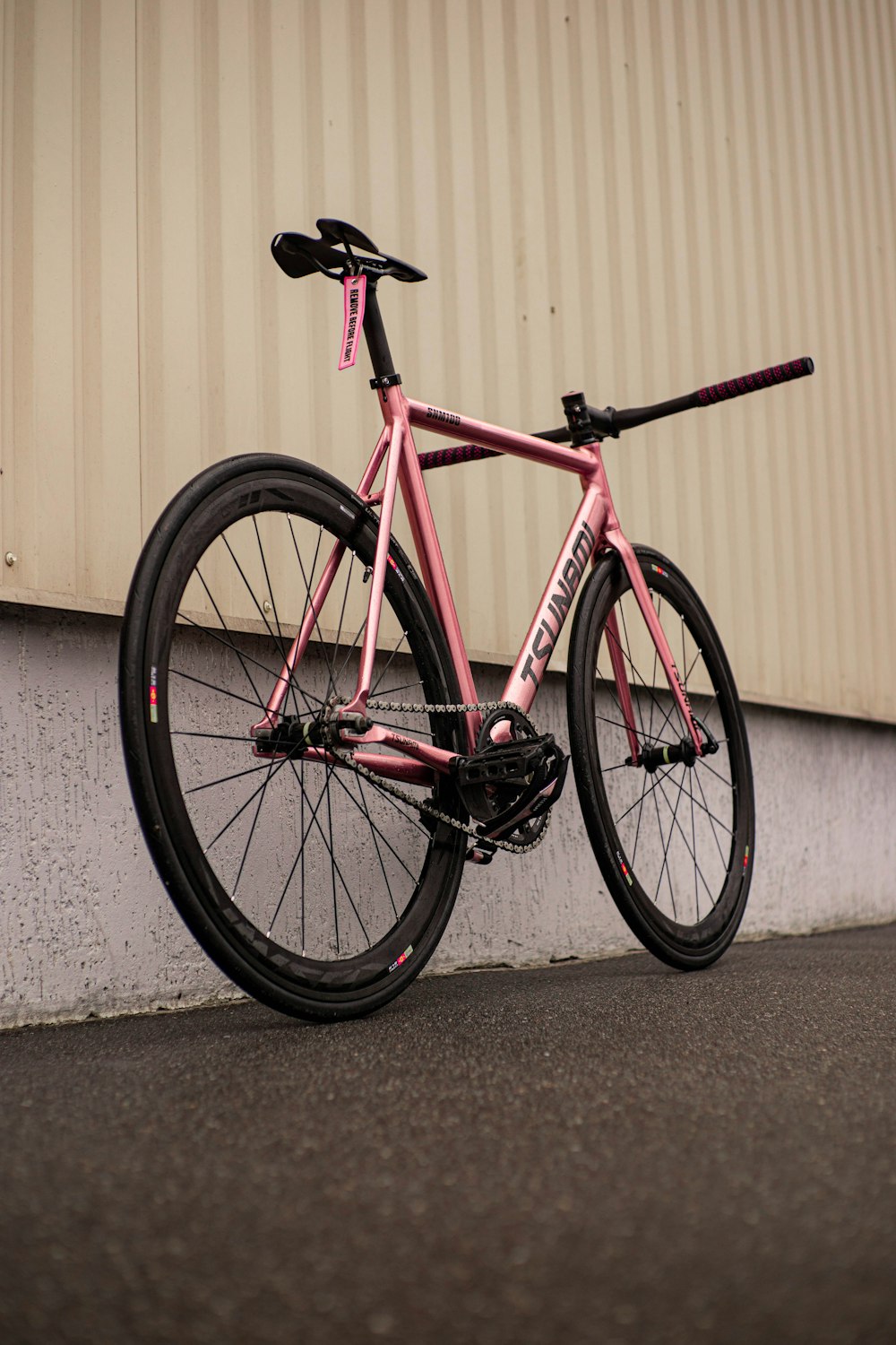 a pink bike parked next to a building