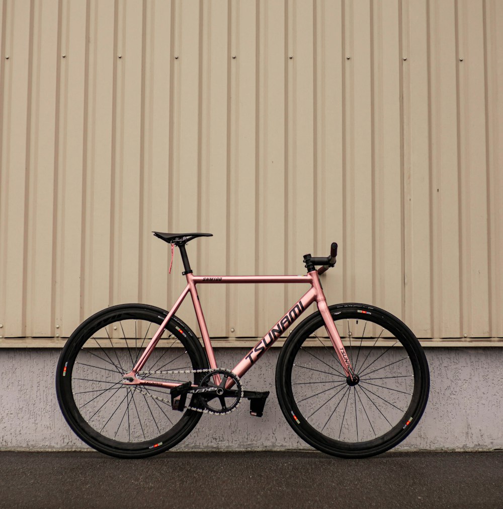 a pink bike parked next to a building