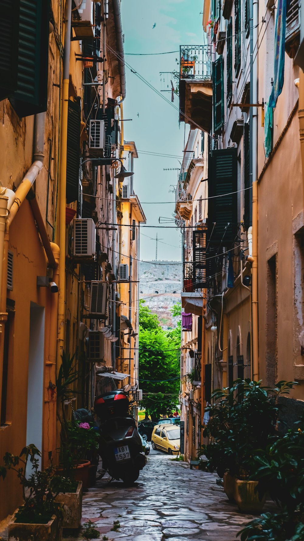 a narrow alley way with cars parked on both sides