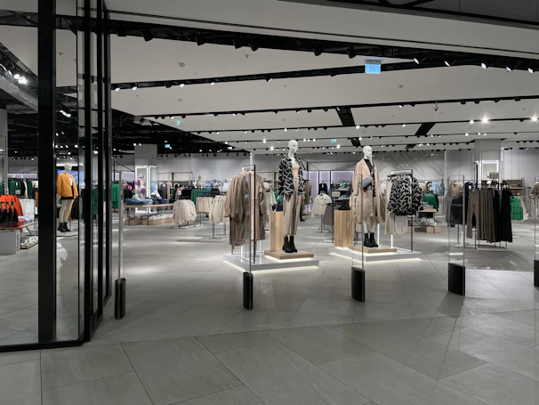 Sleek display of modern fashion apparel on minimalist mannequins with soft gradient background.