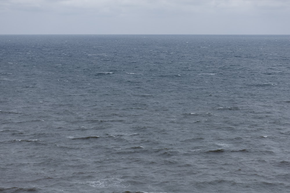 a large body of water with a boat in the distance