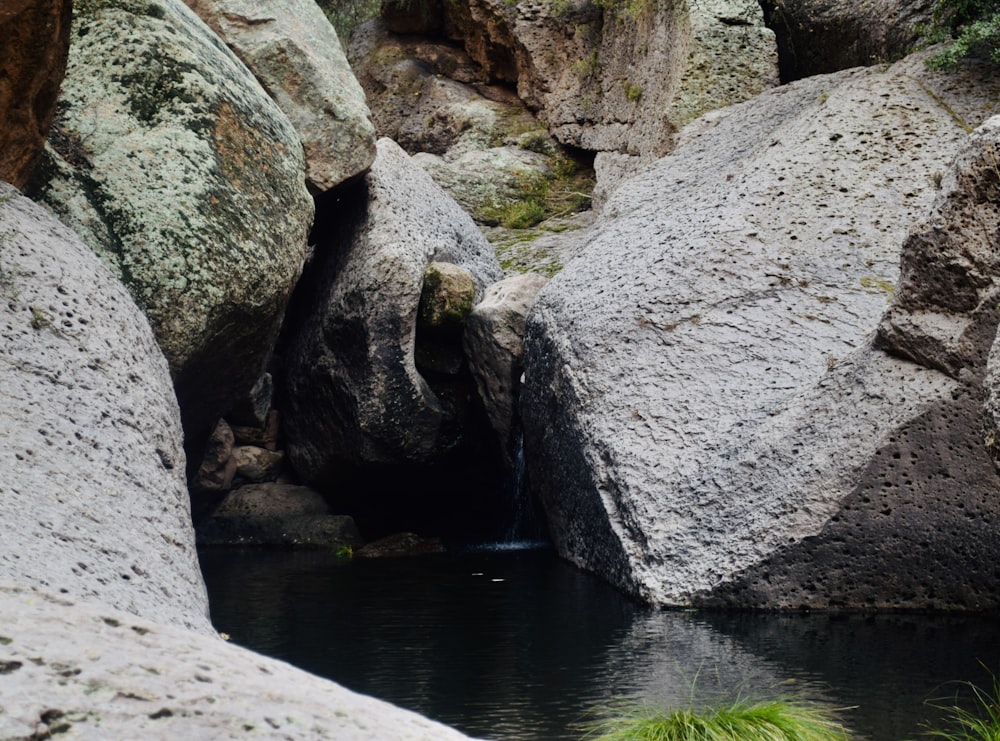 uma pequena piscina de água cercada por grandes rochas