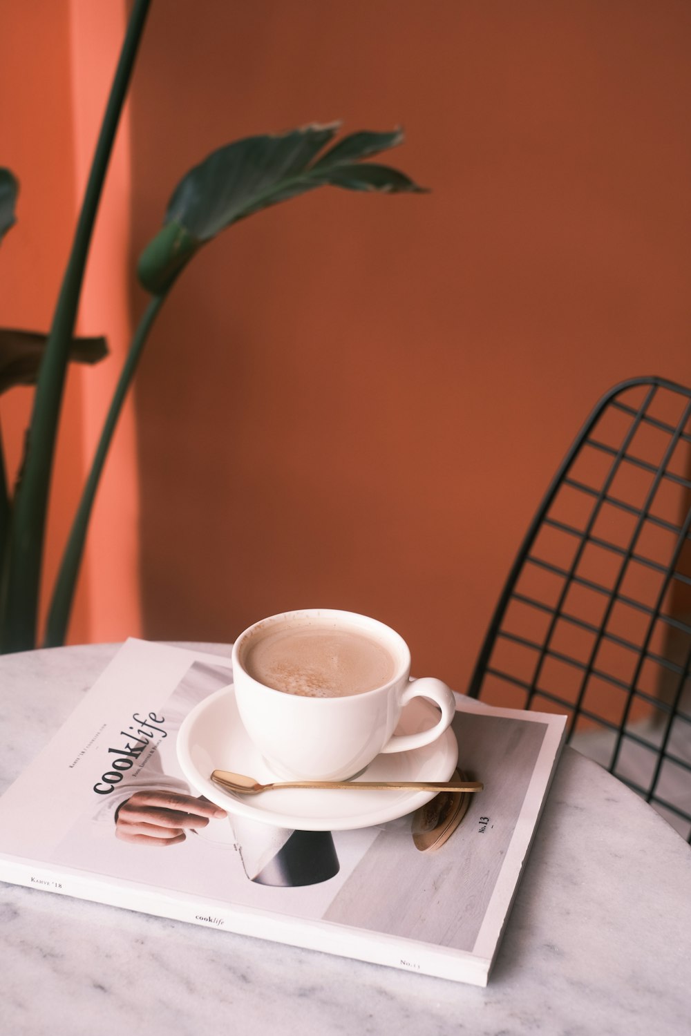 a cup of coffee sitting on top of a magazine