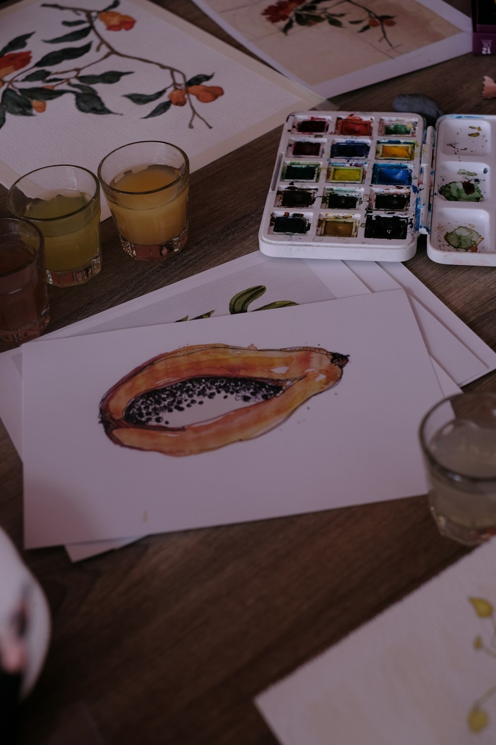 a wooden table topped with cards and watercolors