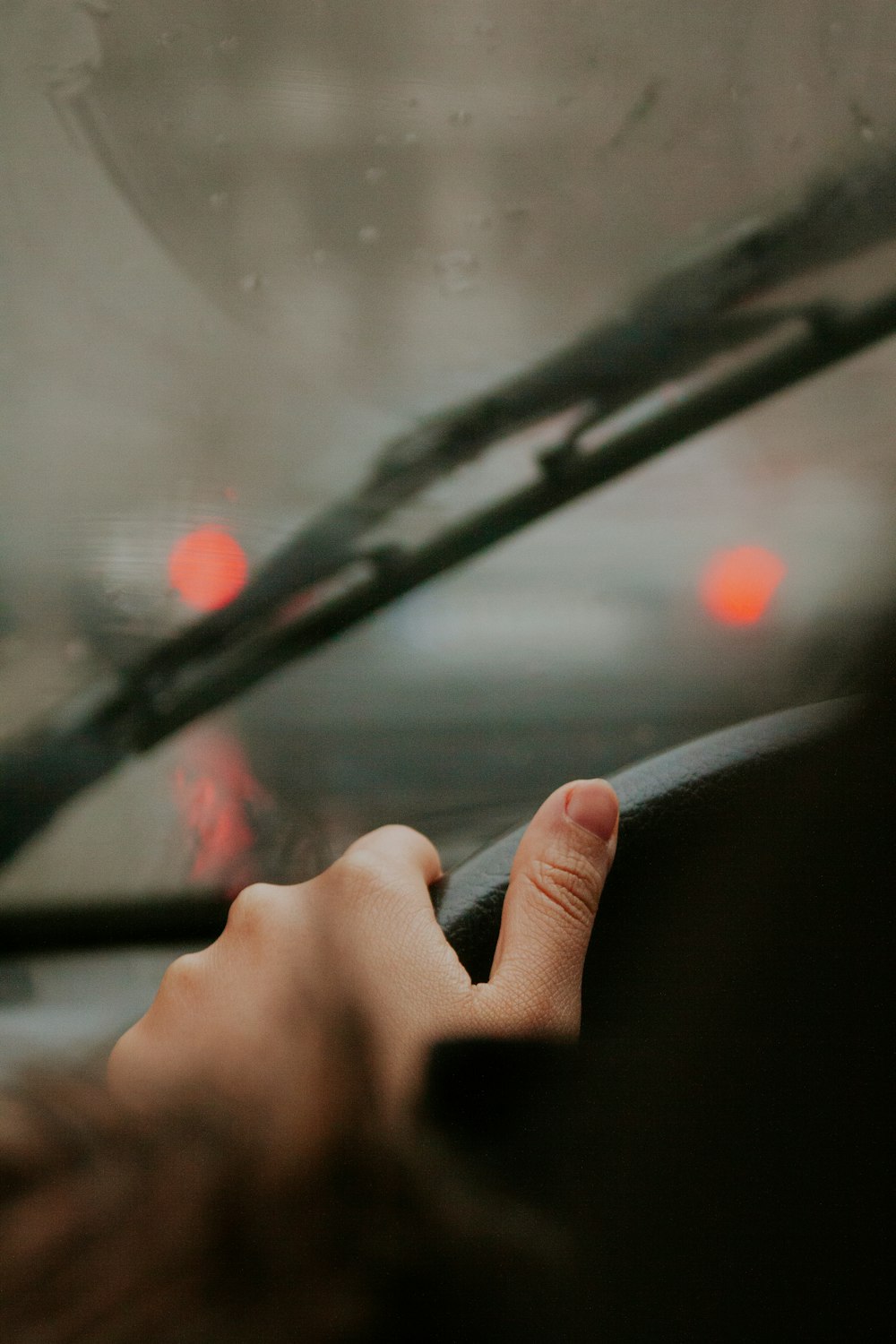 a person holding the steering wheel of a car