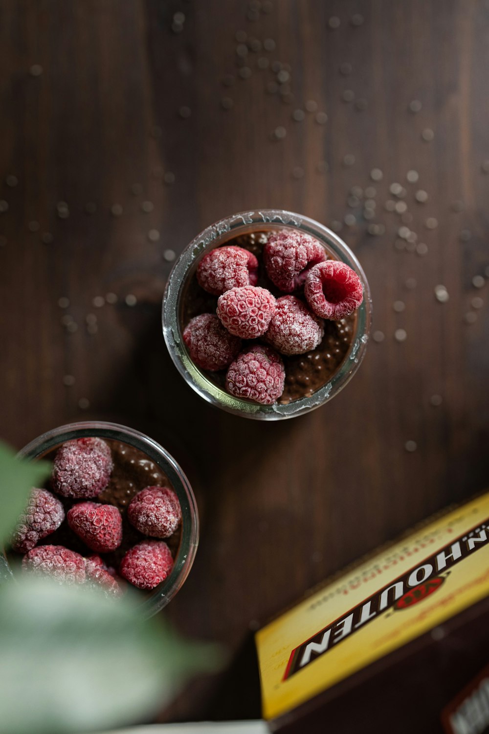 a couple of glasses filled with raspberries on top of a table