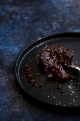 Close-up of a rich chocolate lava cake with molten center on a rustic plate.