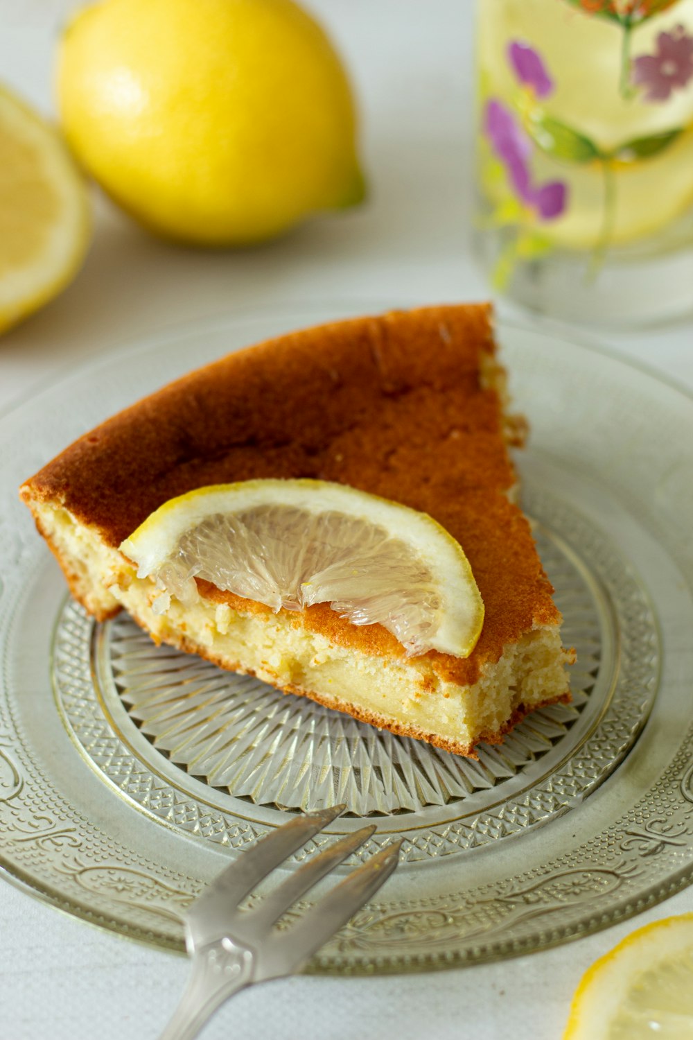 a slice of lemon cake on a plate with a fork