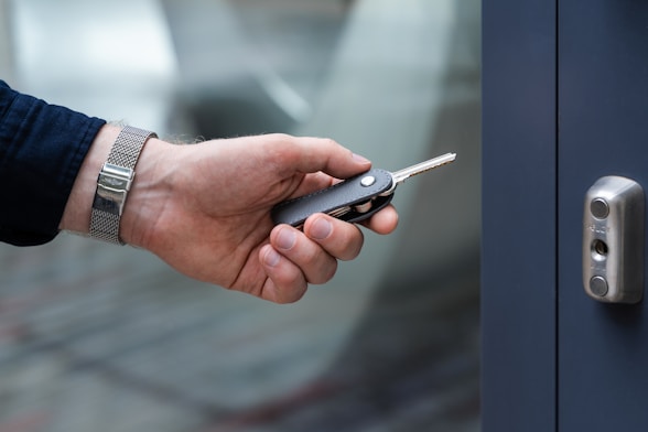 a hand holding a cell phone in front of a door