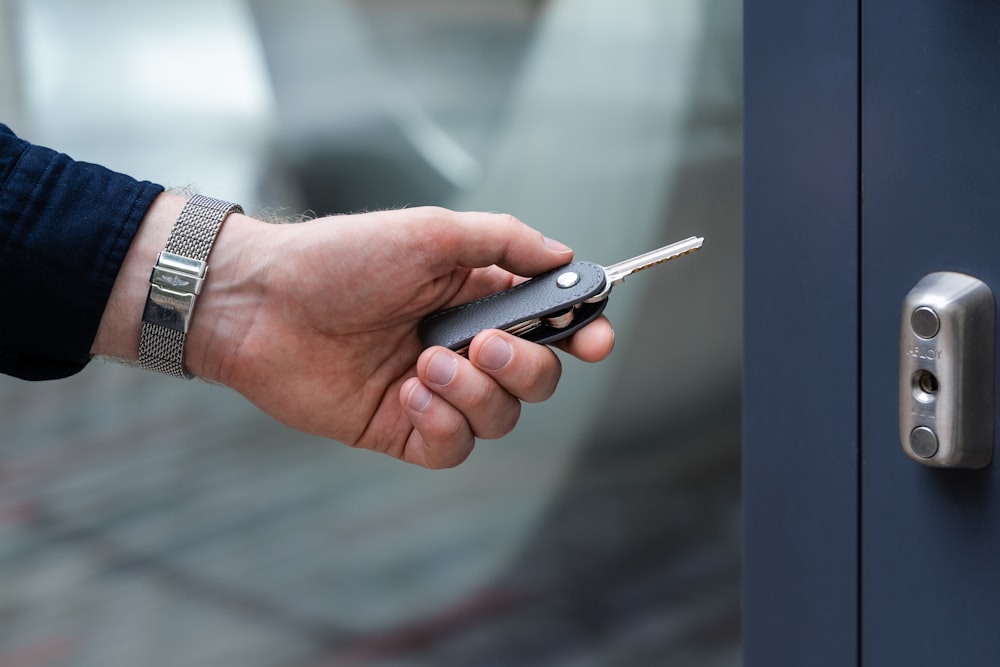 a hand holding a cell phone in front of a door