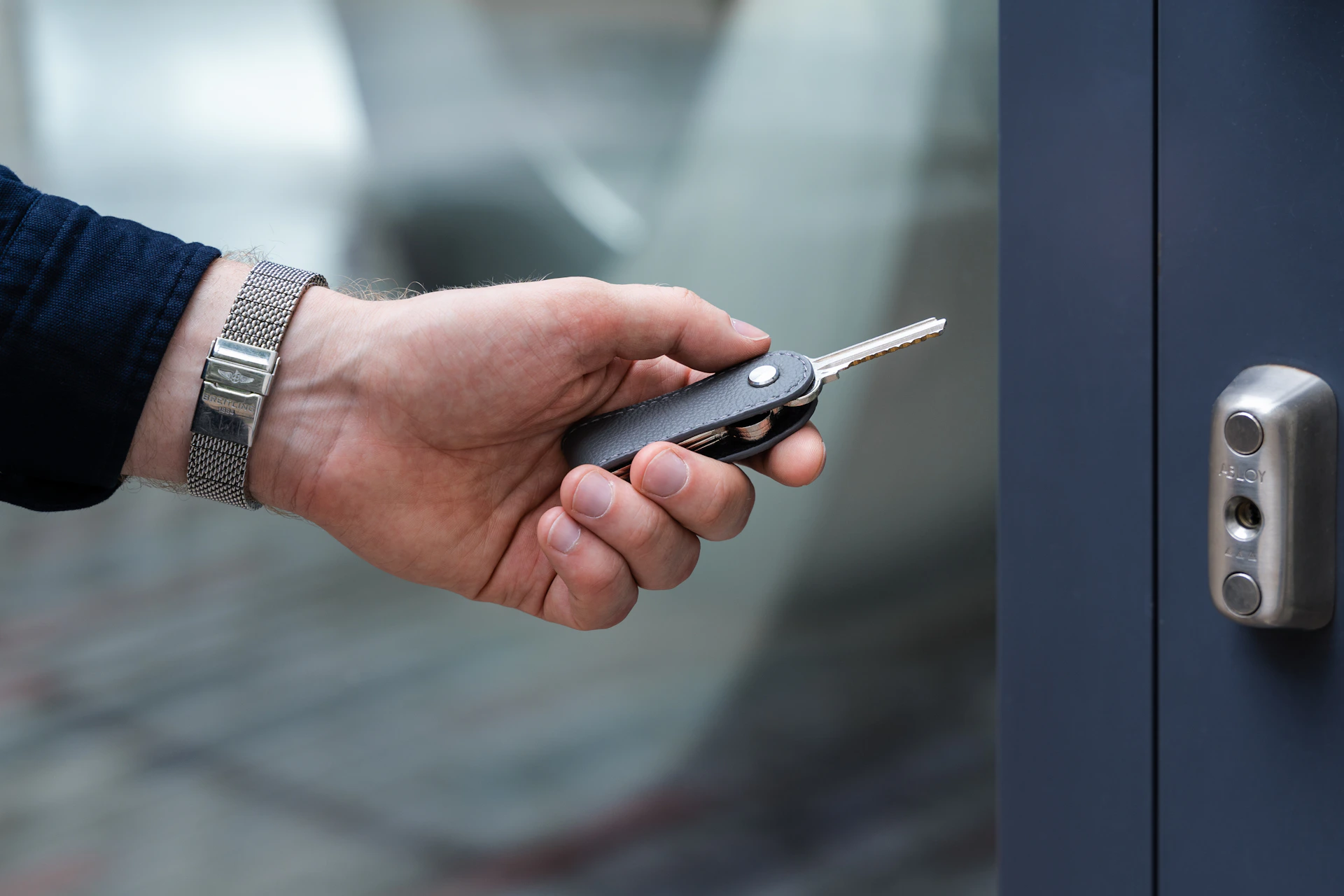 a hand holding a cell phone in front of a door