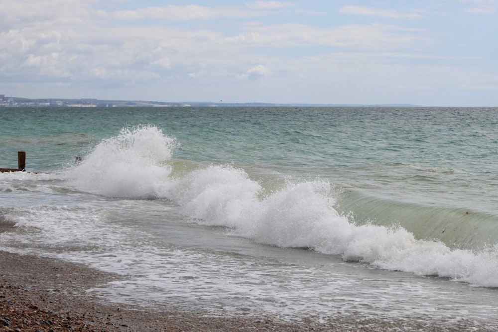 a wave crashes into the shore of a beach