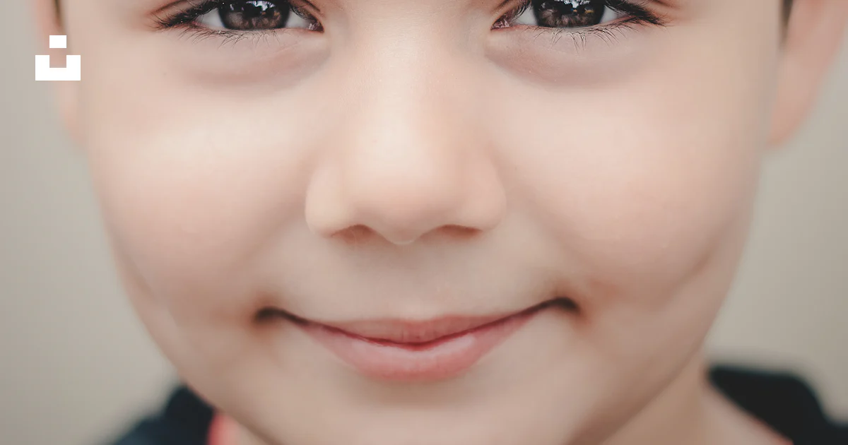 A close up of a child's face smiling photo – Free Portrait Image on ...