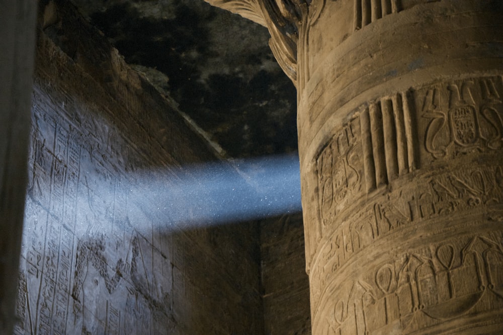 a beam of light shines from behind a pillar