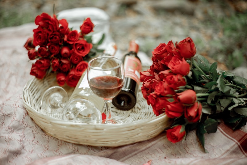 a glass of wine and some flowers on a table