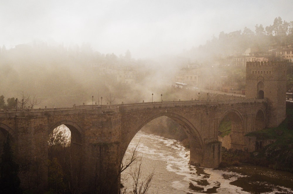 a bridge over a river with a castle in the background