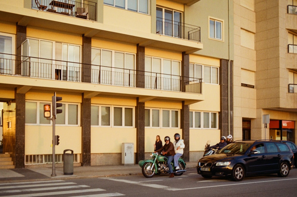 a couple of people riding a motorcycle down a street