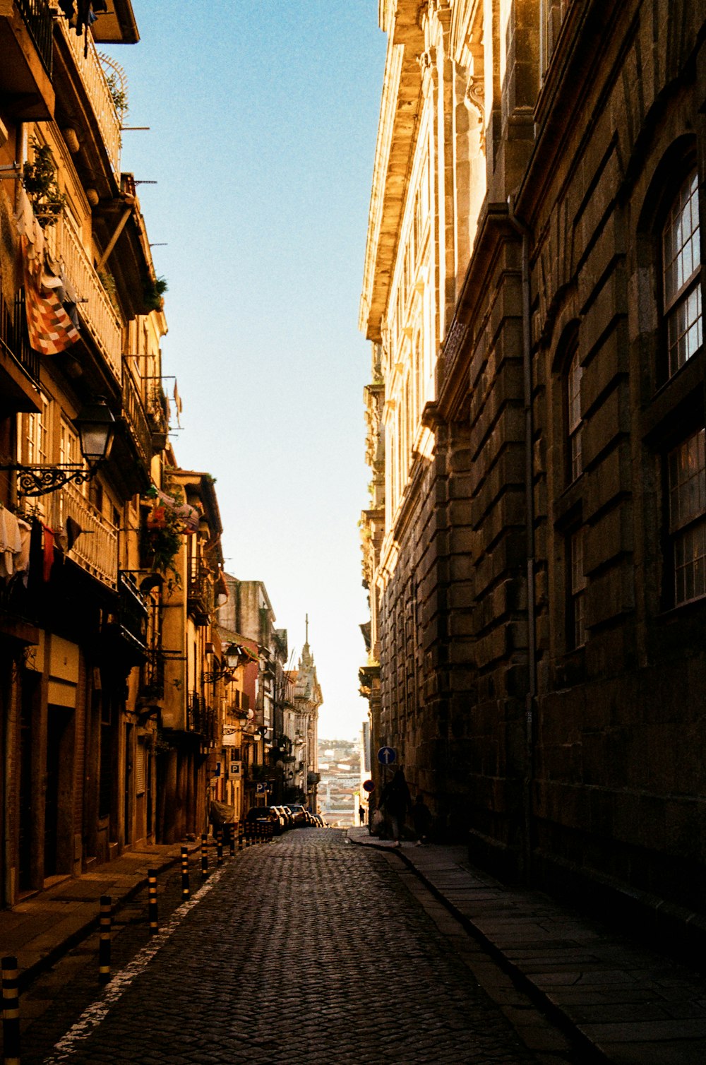 a cobblestone street with a clock tower in the distance