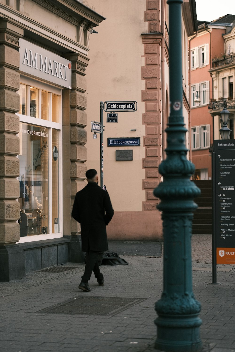 a man walking down a street next to a tall building