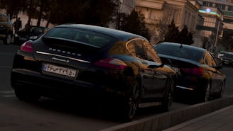 a couple of black cars parked next to each other