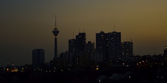 City skyline at dusk with illuminated office towers.