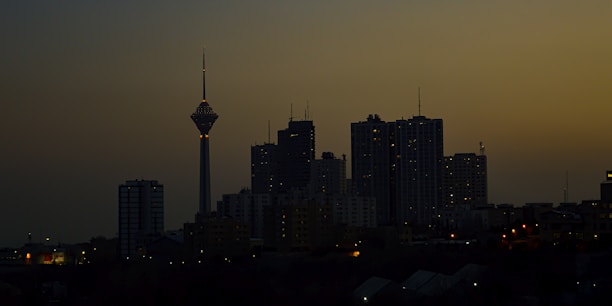 City skyline at dusk with illuminated office towers.