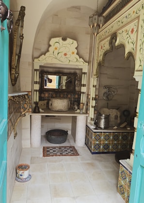 A Moroccan bath setup with traditional tiles and steam, inviting guests to unwind.