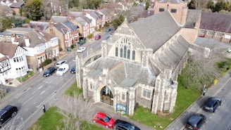 an aerial view of a church with cars parked in front of it
