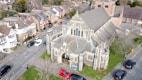 an aerial view of a church with cars parked in front of it