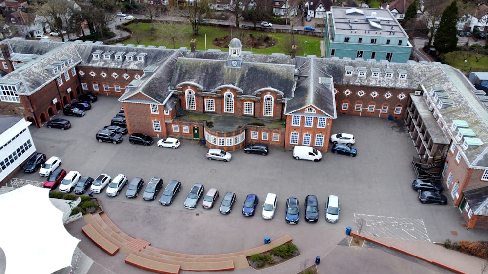 an aerial view of a large building with cars parked in front of it
