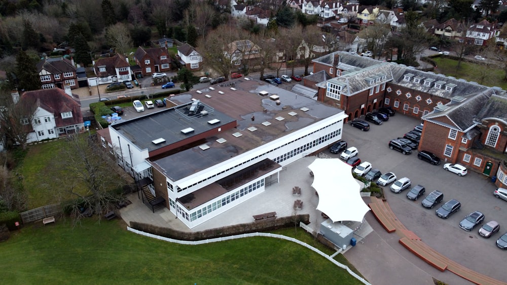 an aerial view of a building with cars parked in front of it