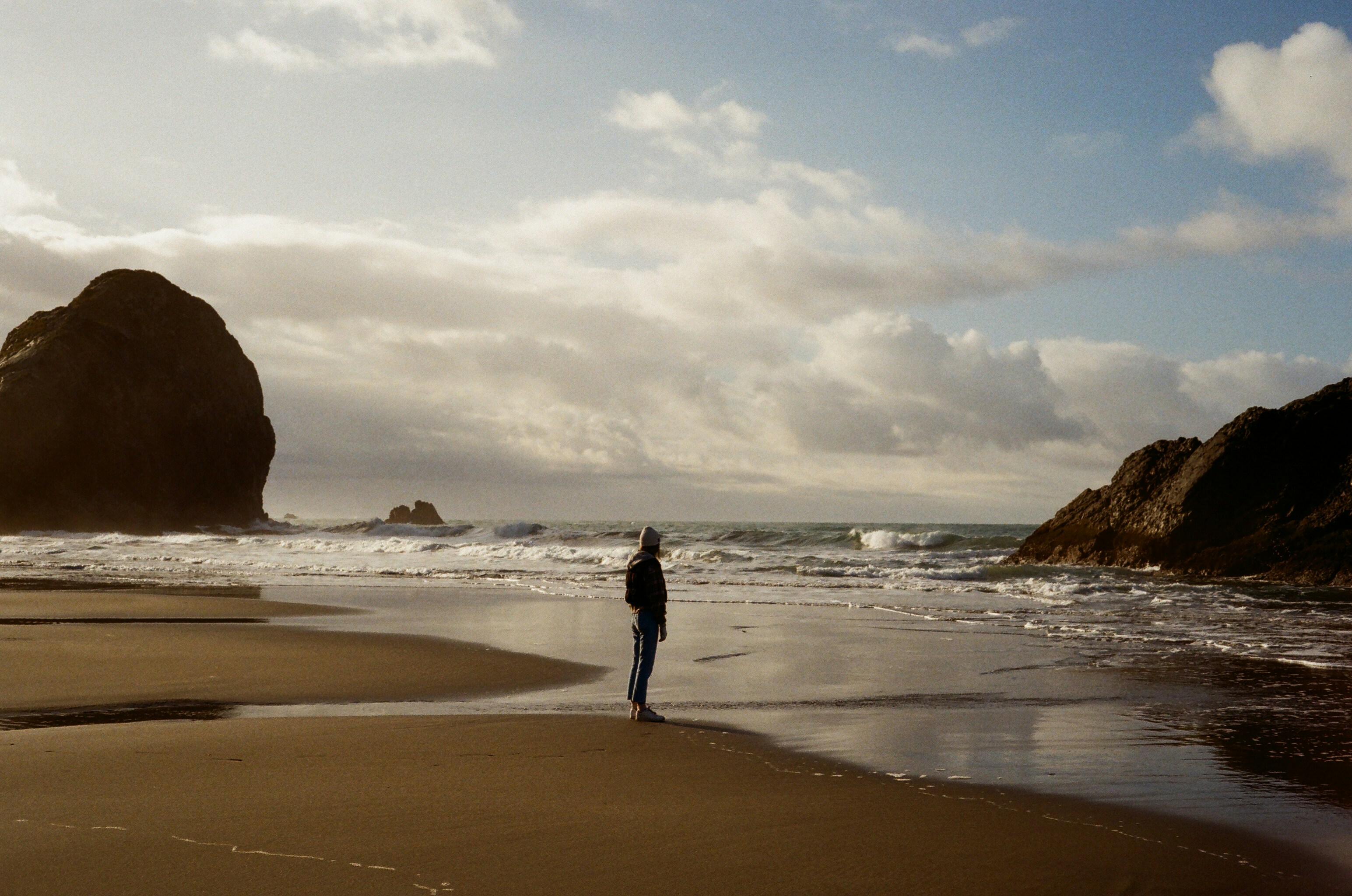 a person standing on a beach next to the ocean