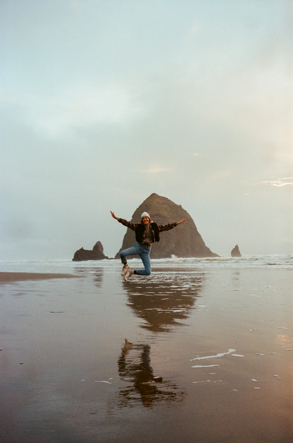 a person jumping in the air on a beach