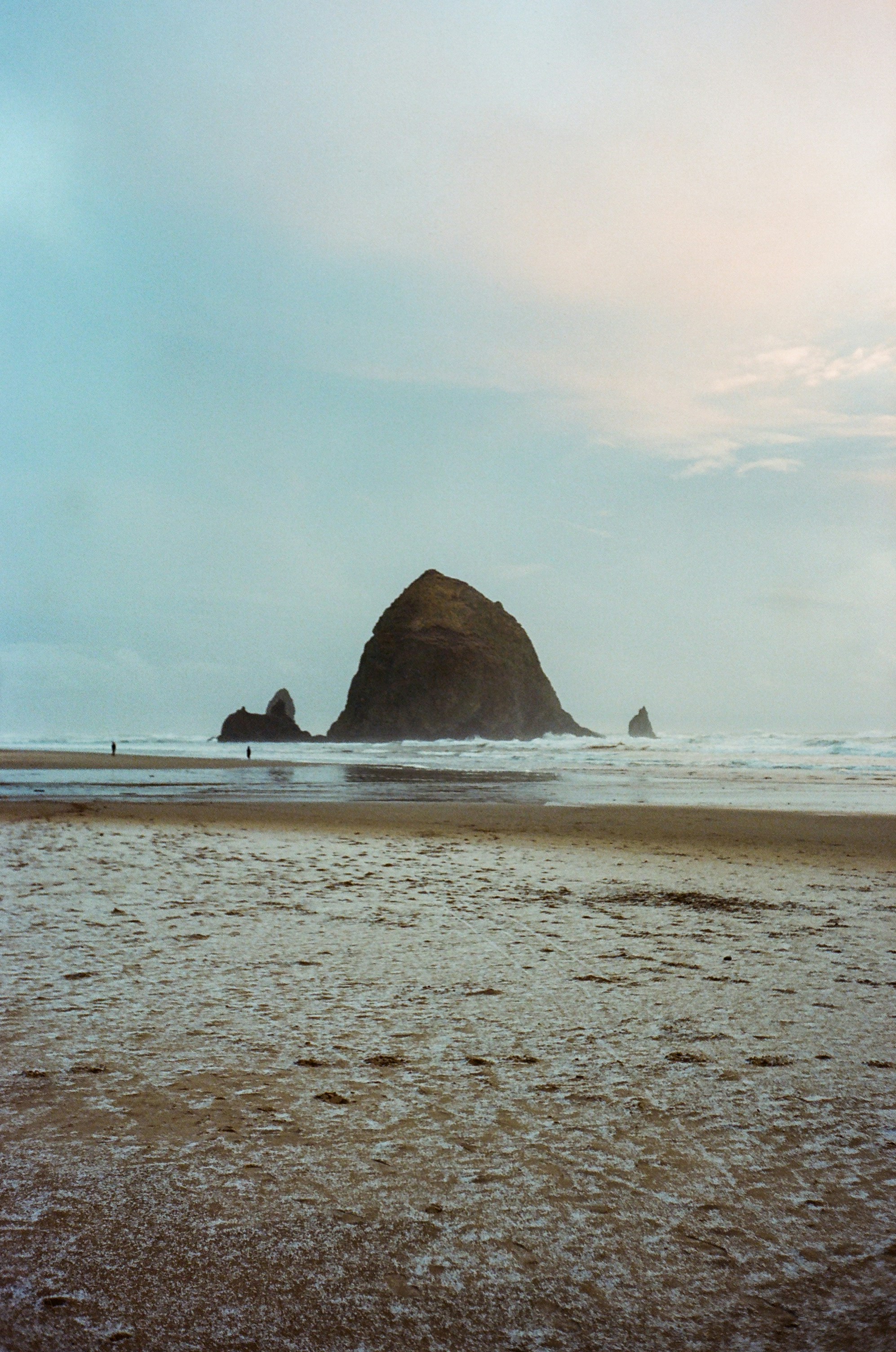 a person walking on a beach with a surfboard