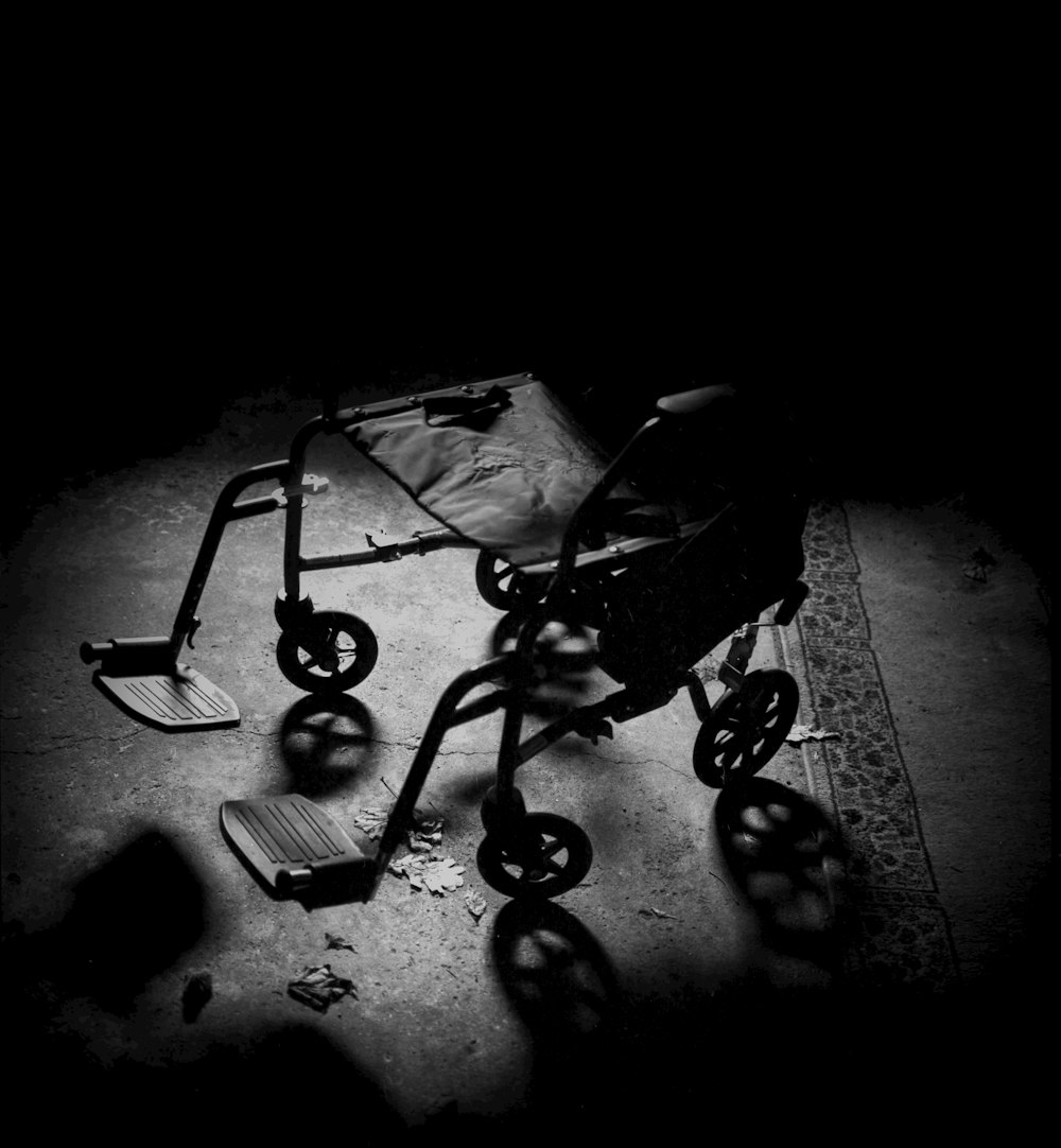a black and white photo of a broken stroller