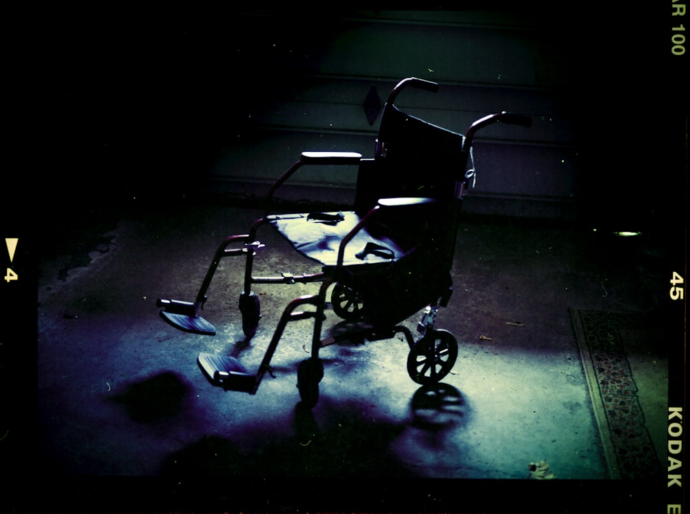 ein Rollstuhl, der in einem dunklen Raum auf dem Boden sitzt