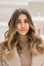 a woman with long hair wearing a coat