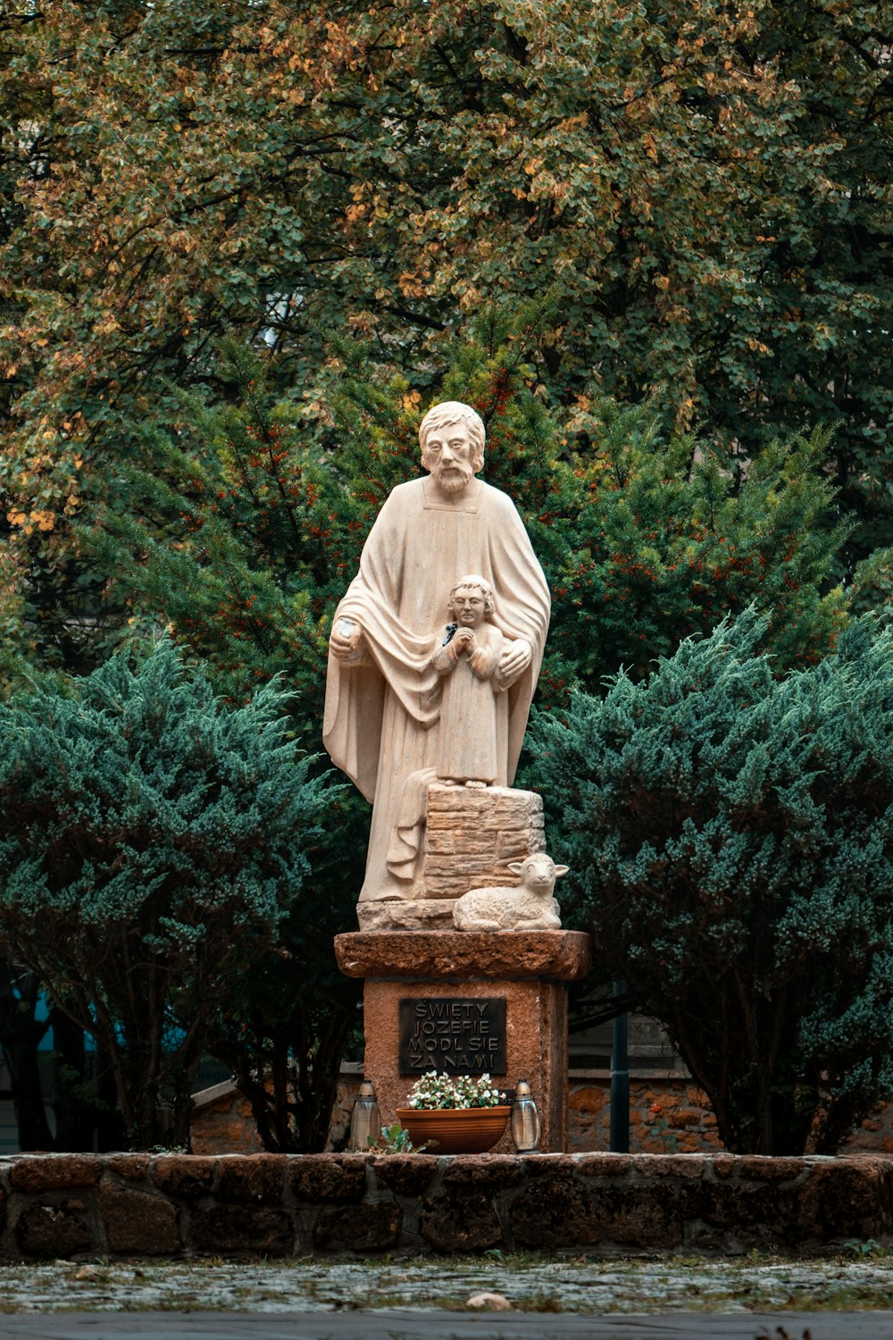 a statue of a man holding a pot of flowers