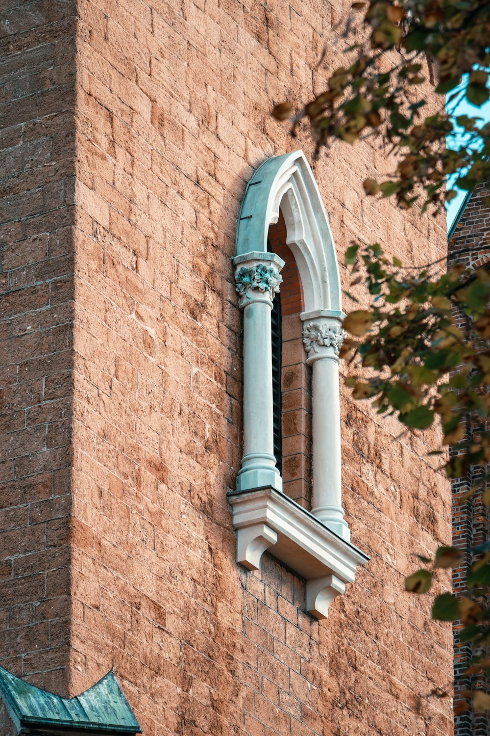 a tall brick building with a window and a clock